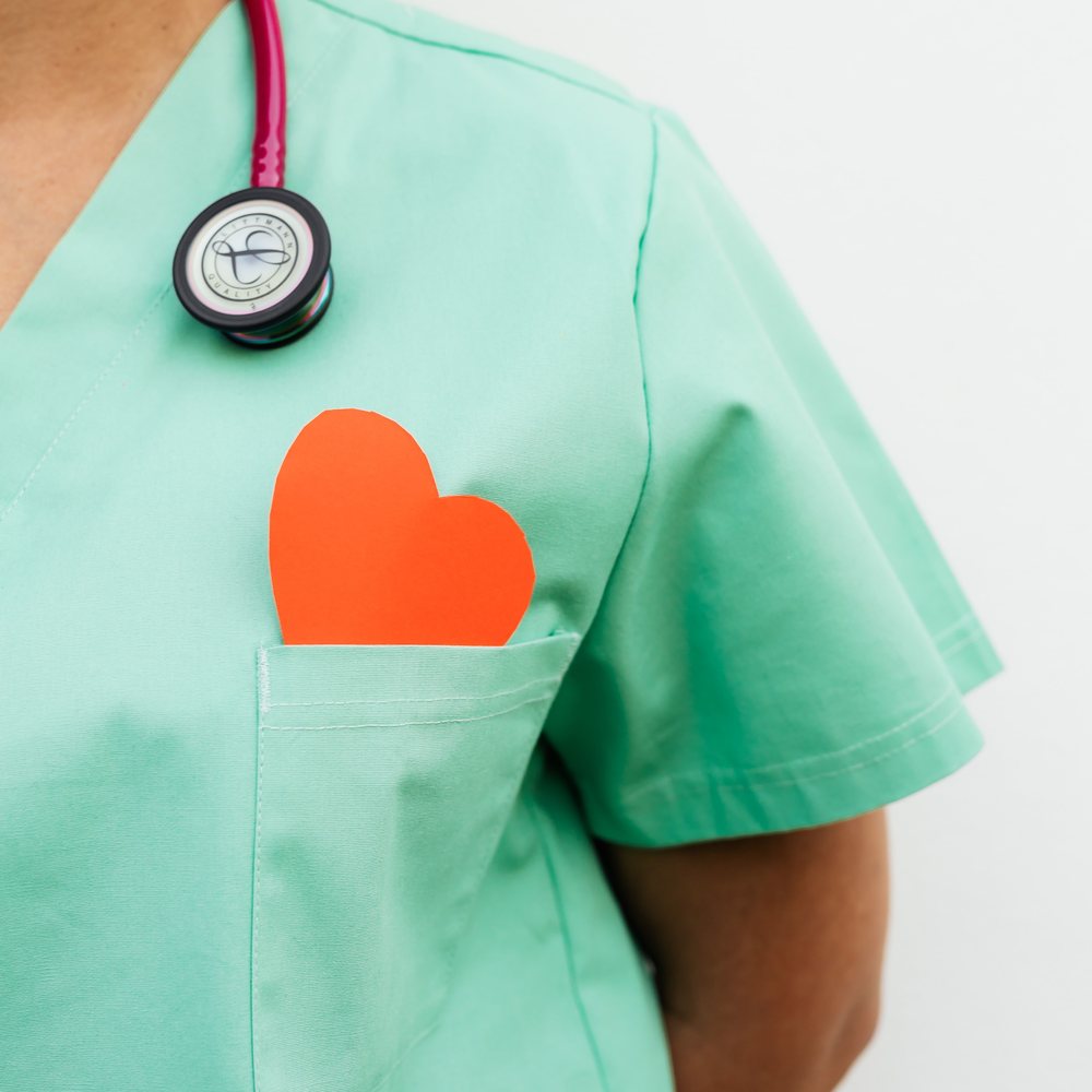 A paper heart tucked into the pocket of a set of scrubs.