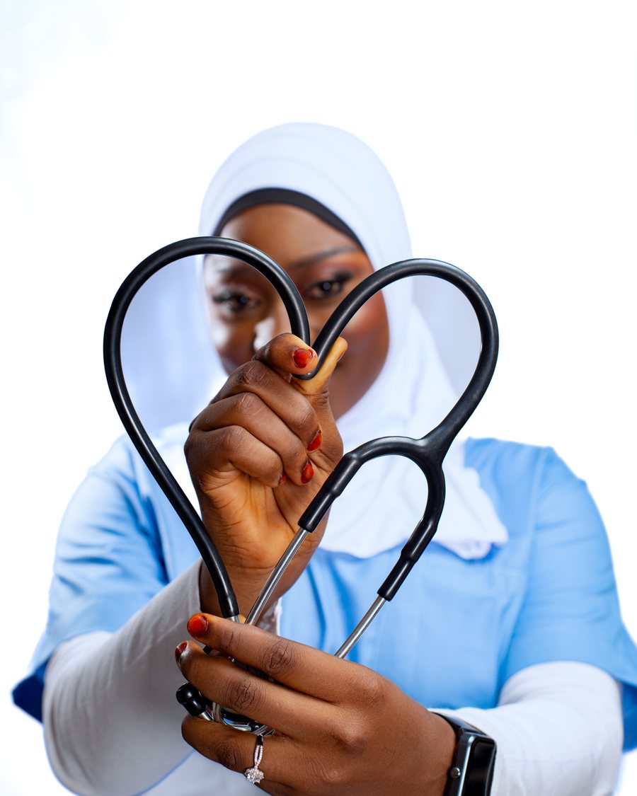 A healthcare professional holding a stethoscope shaped into a heart.