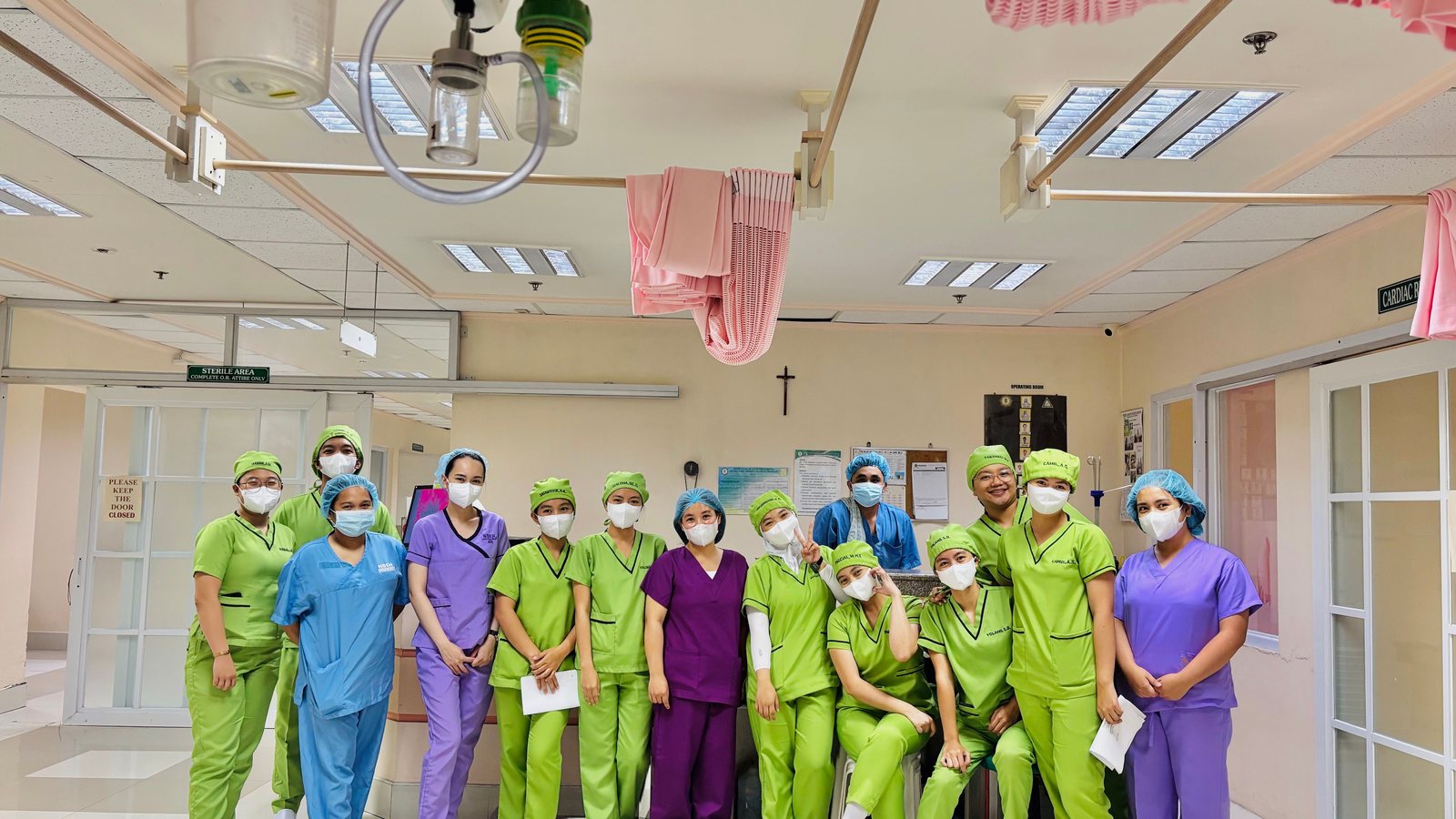 A team of clinical staff in scrubs gathered in a hospital unit.